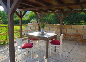 Brown wood gazebo over a table and chairs